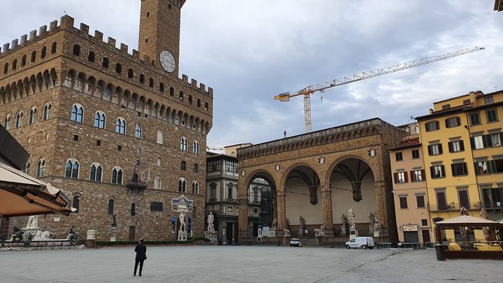 Palazzo Vecchio and the arches of the Loggia dei Lanzi on a quiet, cloudy day.